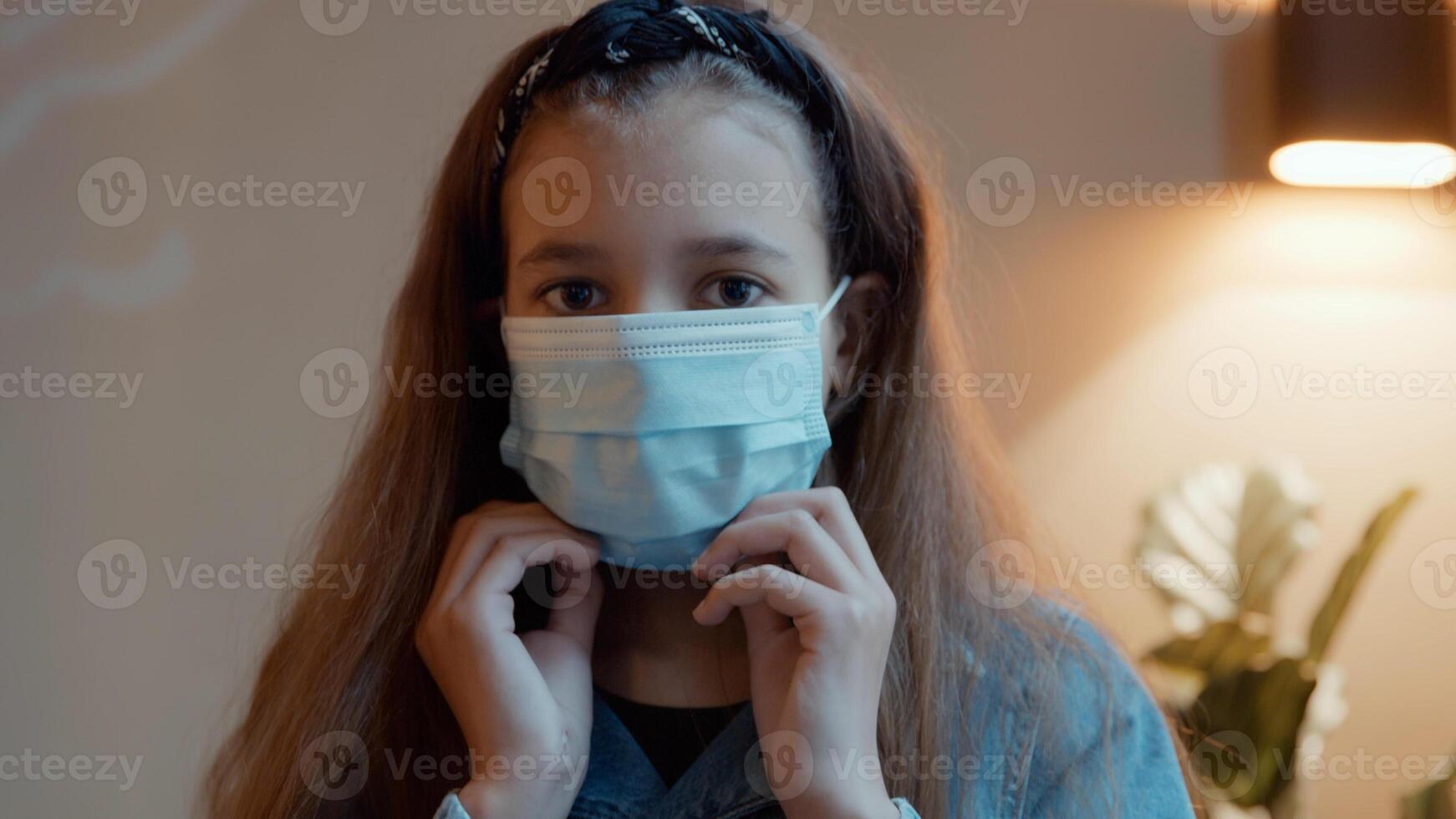 Girl putting on face mask looking into camera lens photo