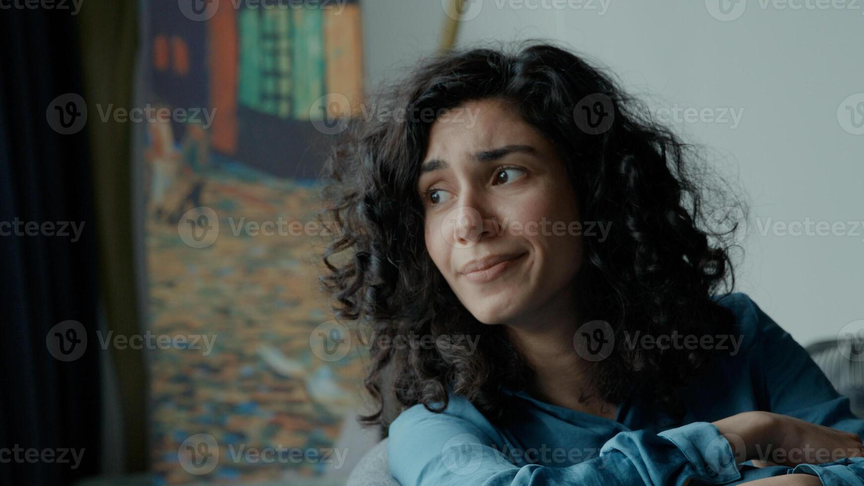 Sad woman sits on couch photo