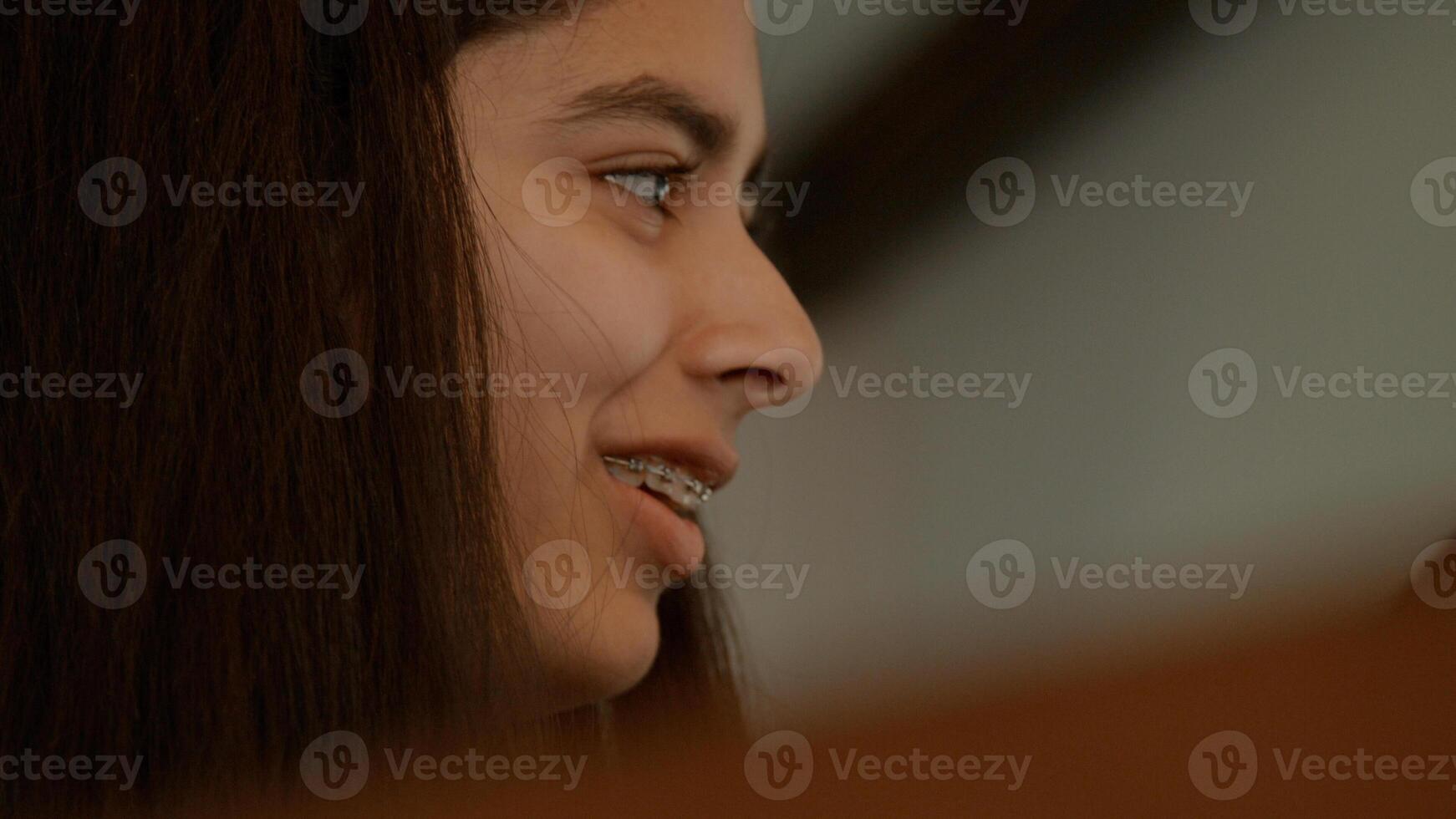 Girl sits at piano talking and smiling and woman sitting next to her photo