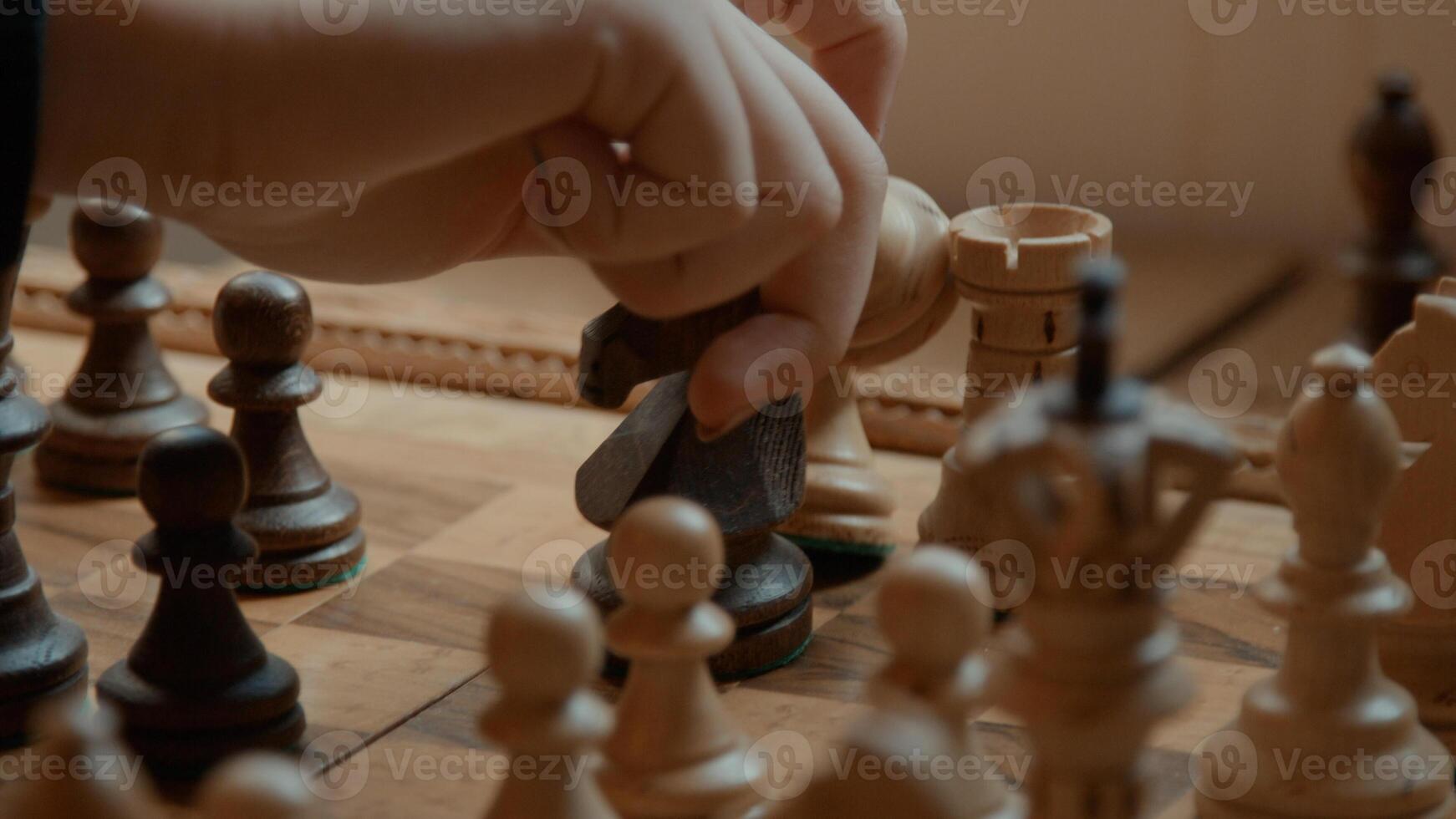 Hand of girl moving and removing chess pieces on chessboard photo