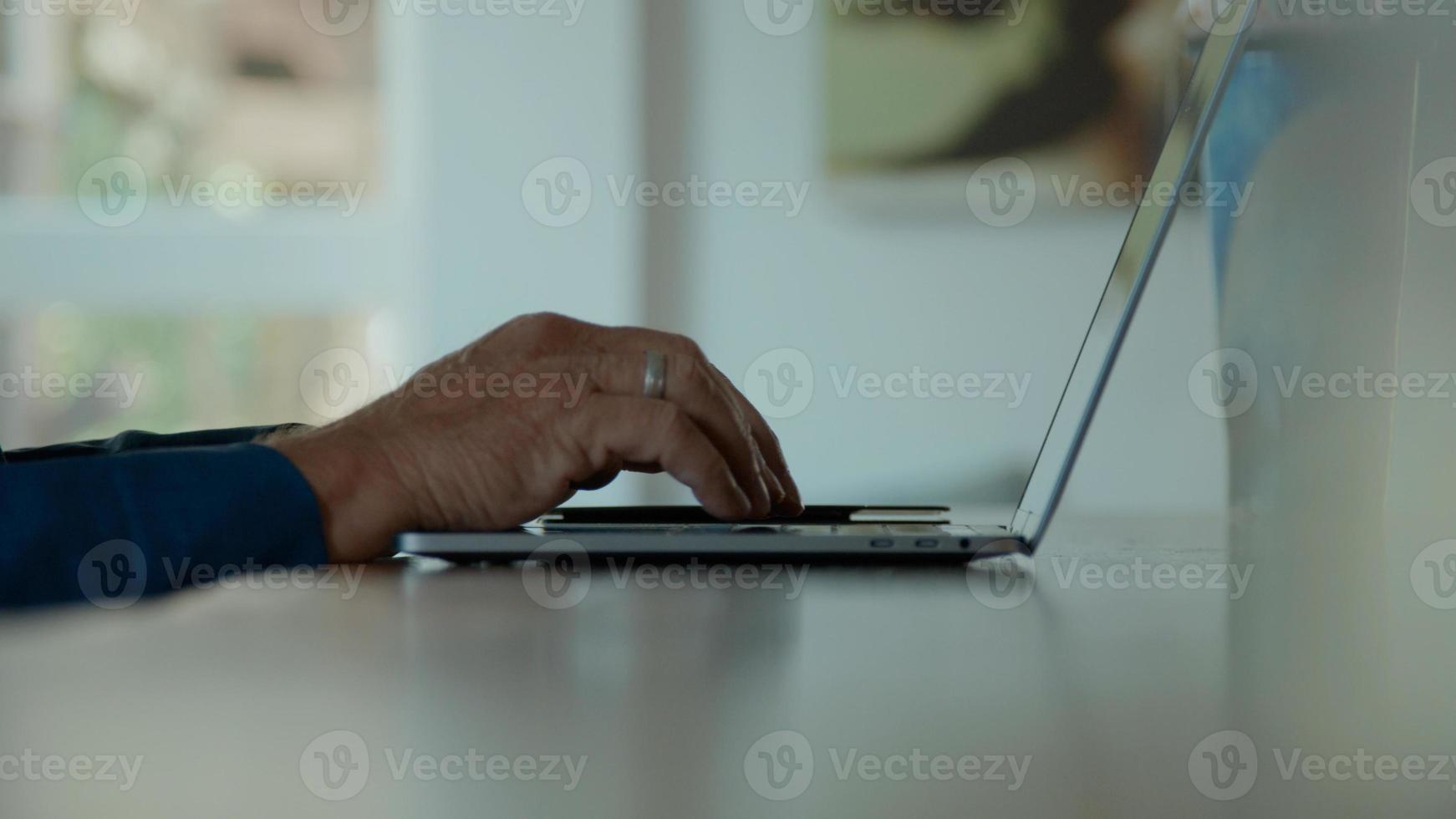 Hands of man typing on keyboard of laptop and man nods photo