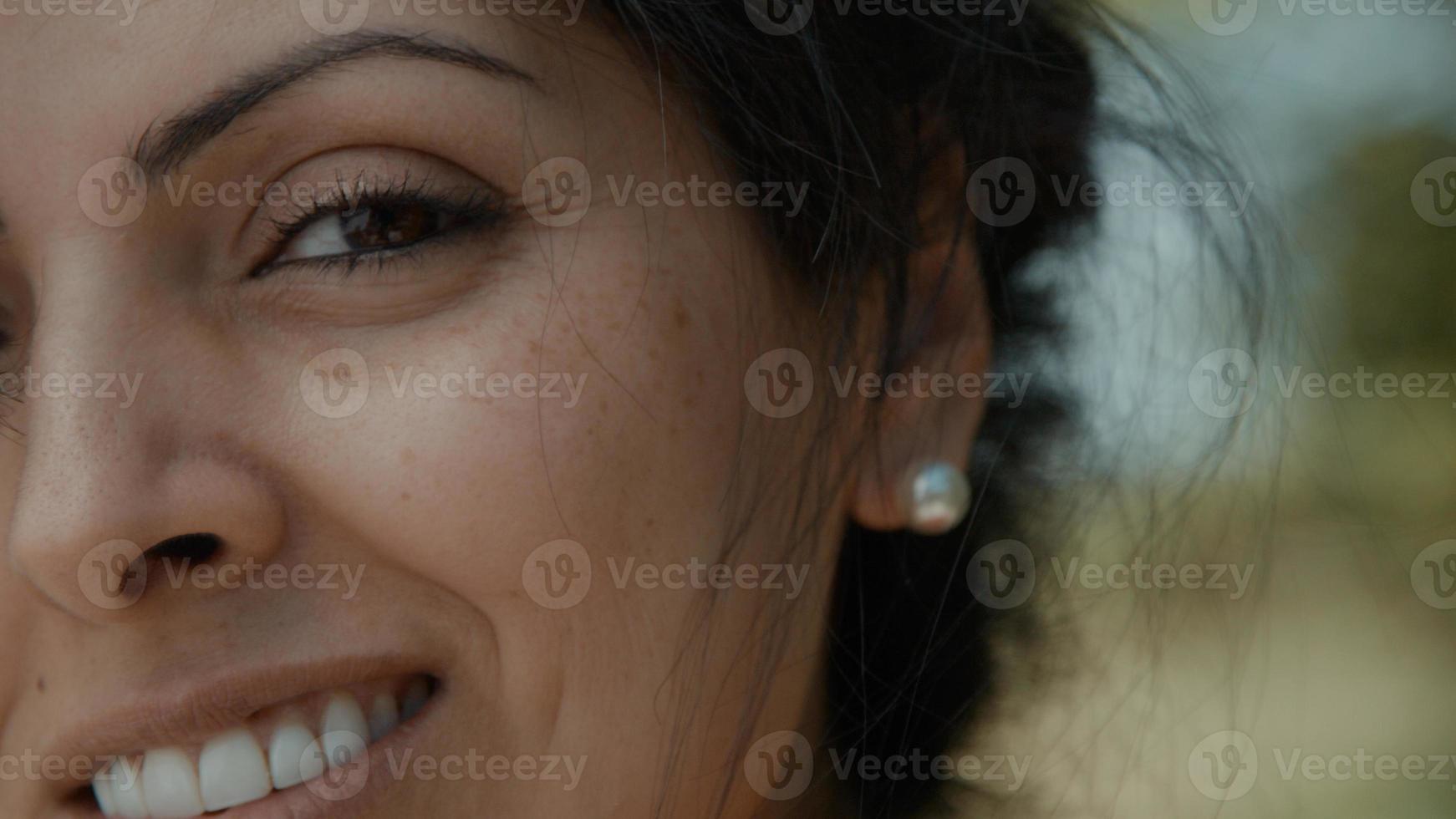 Right half of womens face smiling into camera lens photo