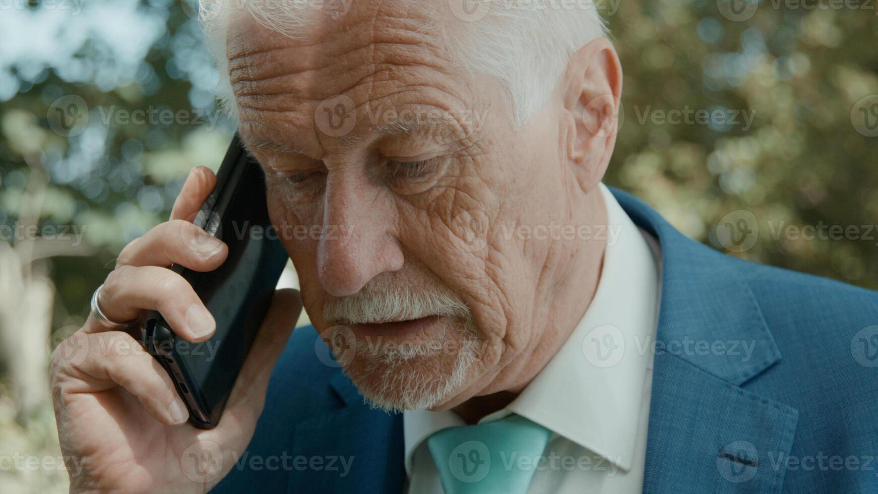 Man standing in green area starting call with smartphone photo