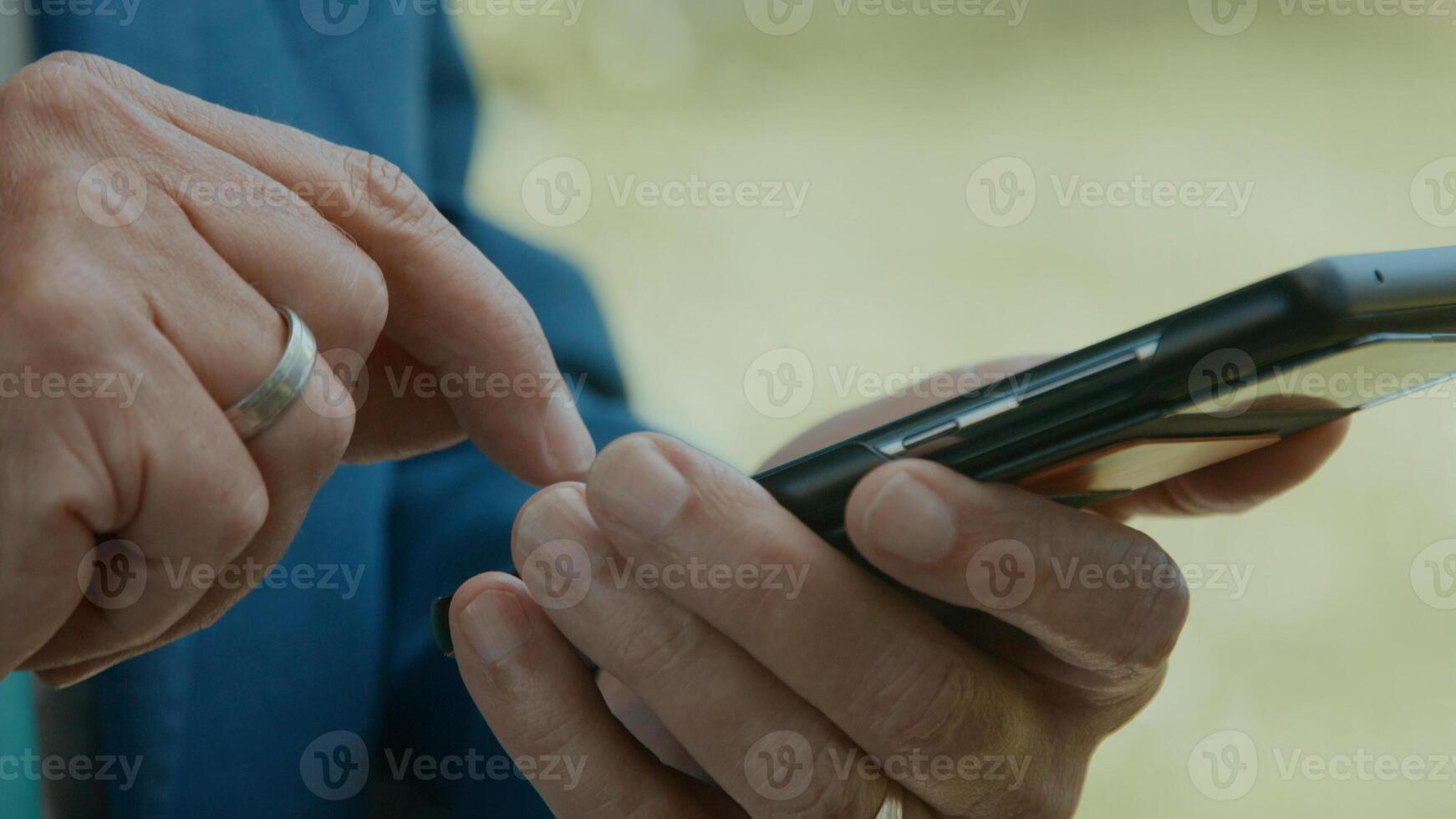 Hands of man in green area typing on smartphone photo