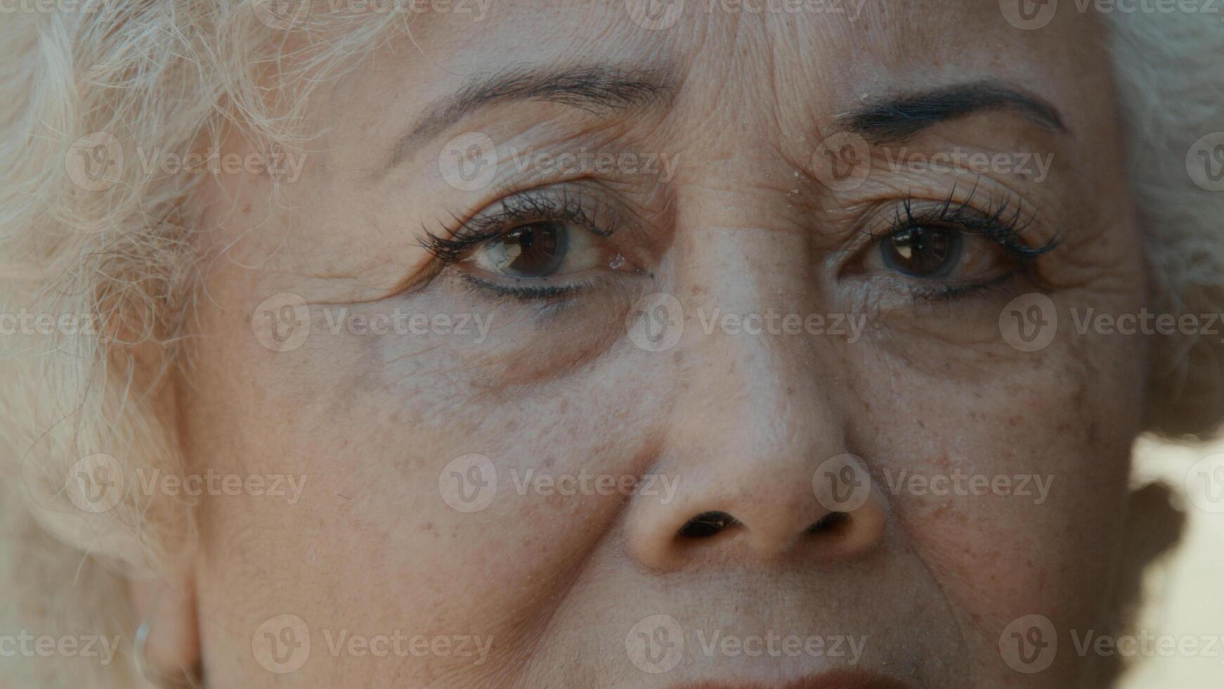 Woman looks serious into camera lens photo