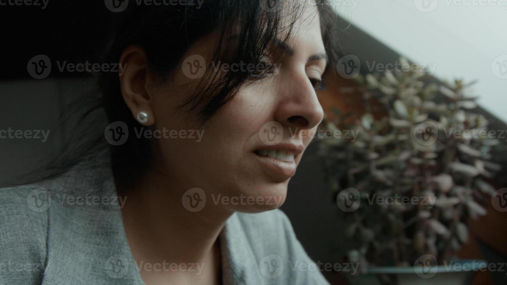 Woman sitting at table scrolling on laptop photo