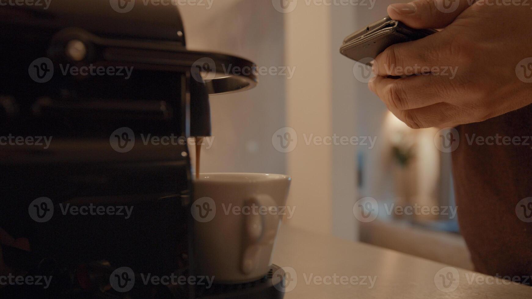 La mano del hombre que sostiene el teléfono inteligente y el café se queda sin máquina foto