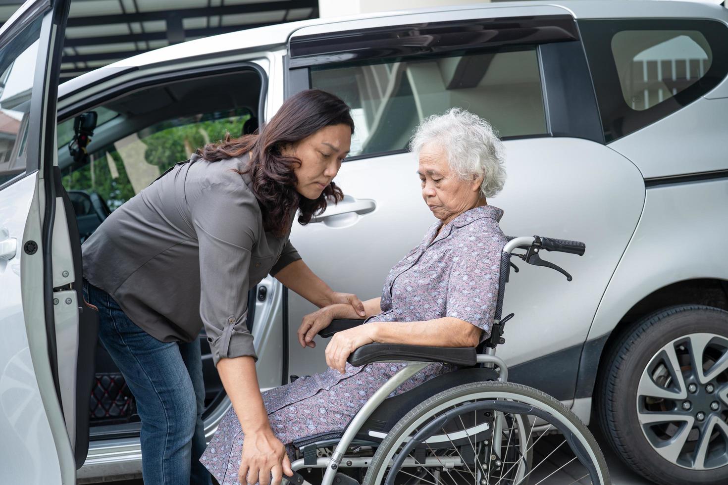 Help and support asian senior patient prepare get to her car photo