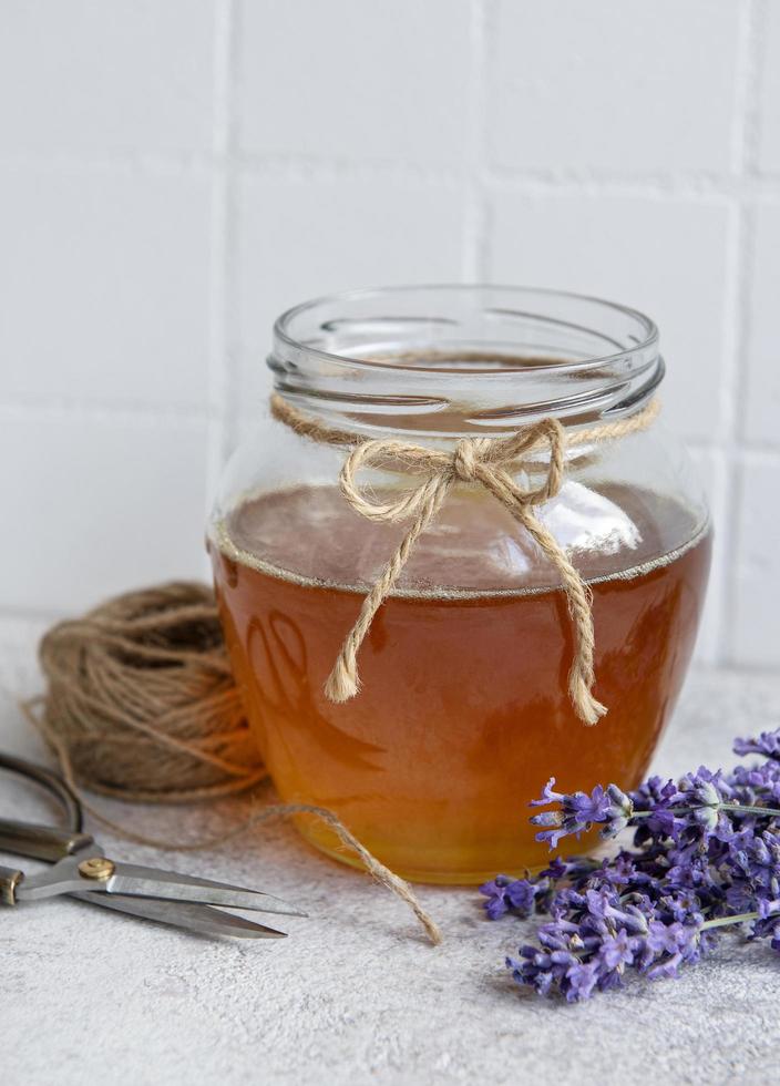 tarro con miel y flores frescas de lavanda foto