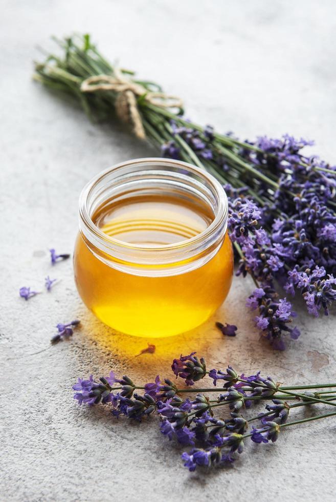 Jar with honey and fresh lavender flowers photo