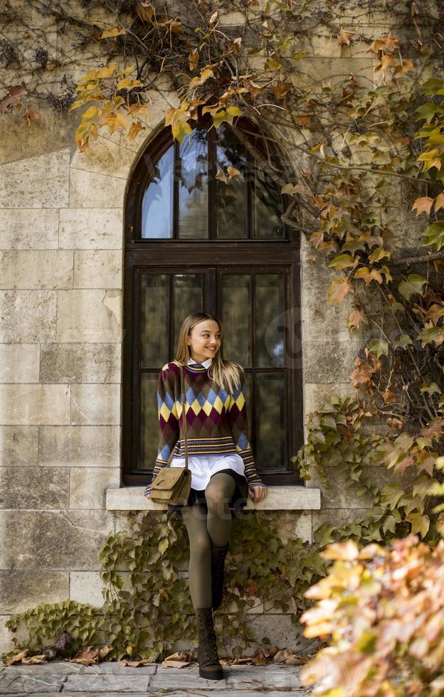 Mujer joven de pie afuera en el soleado día de otoño foto