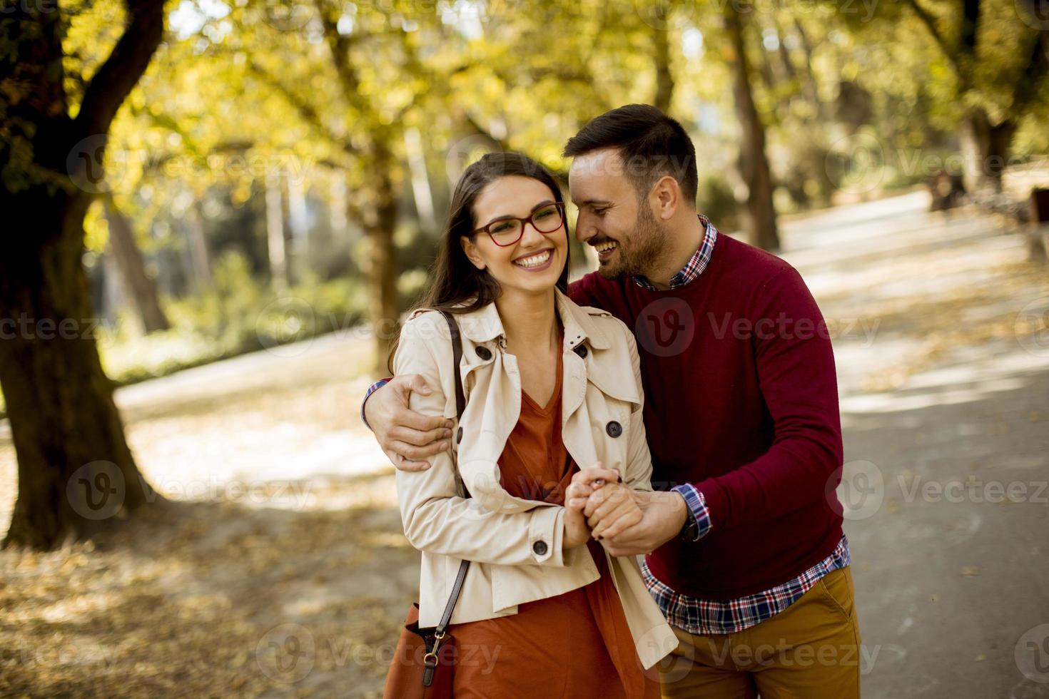 Young woman and man walking in city park holding hands photo