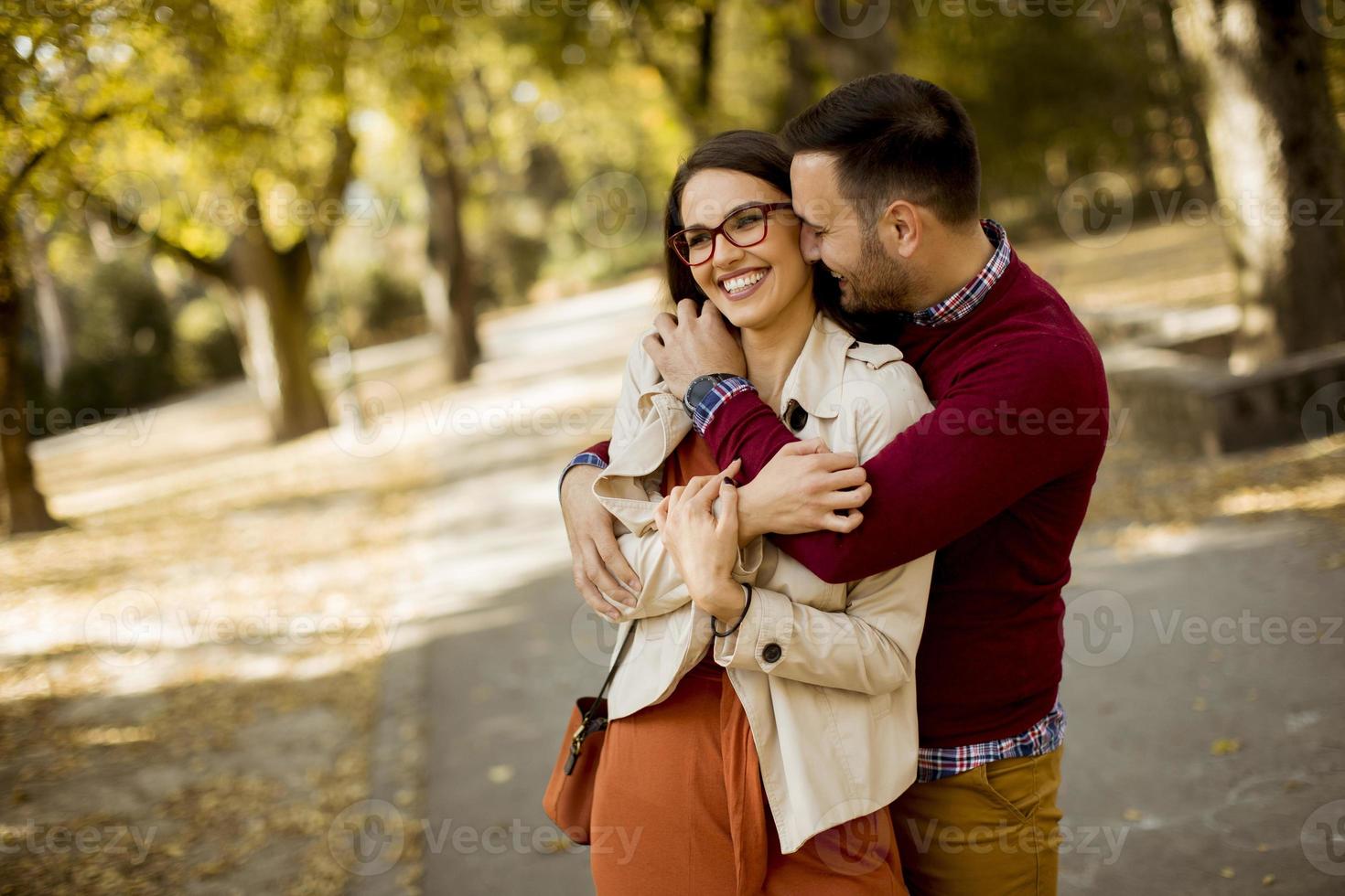 Young woman and man walking in city park holding hands photo