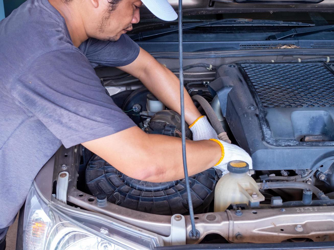 Mechanic holding a block wrench handle while fixing a car. photo