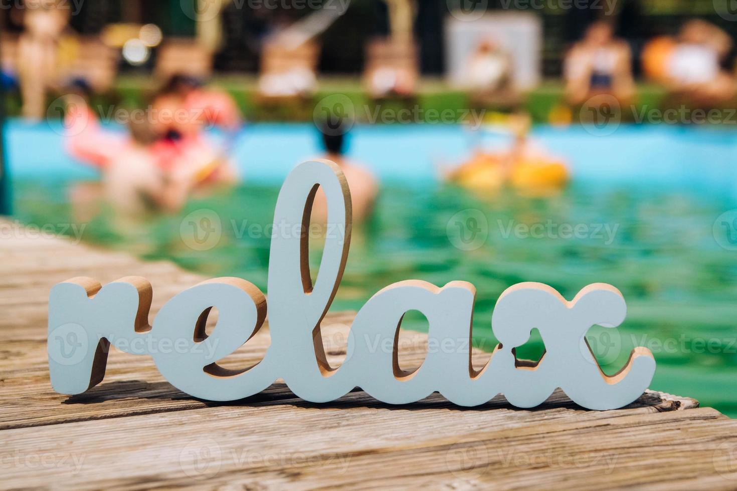 Inscription relax blue in blurred pool background photo