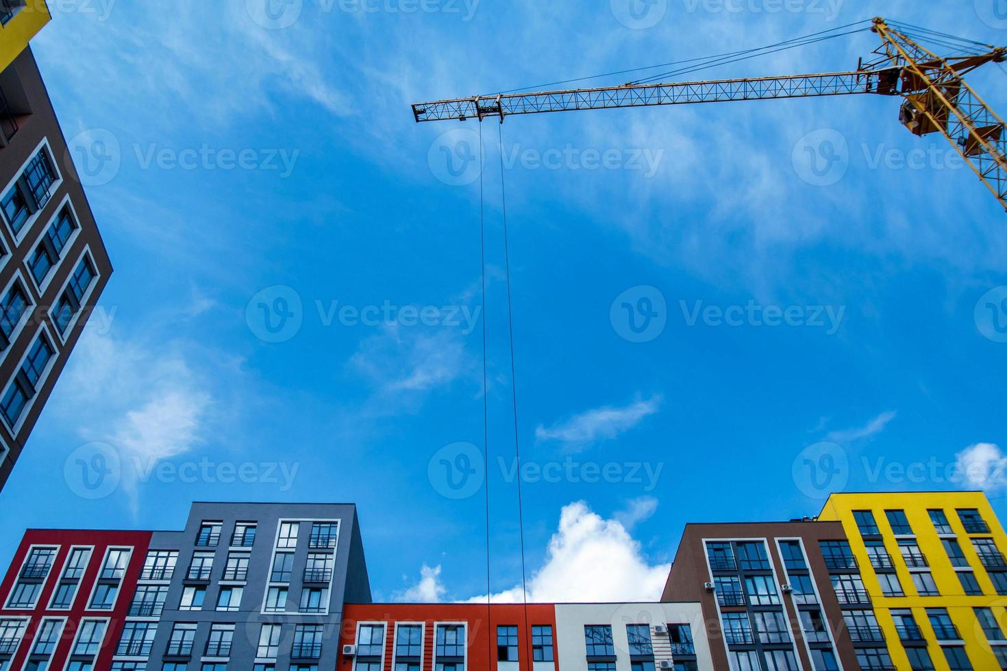 Building crane on the background of colored buildings photo