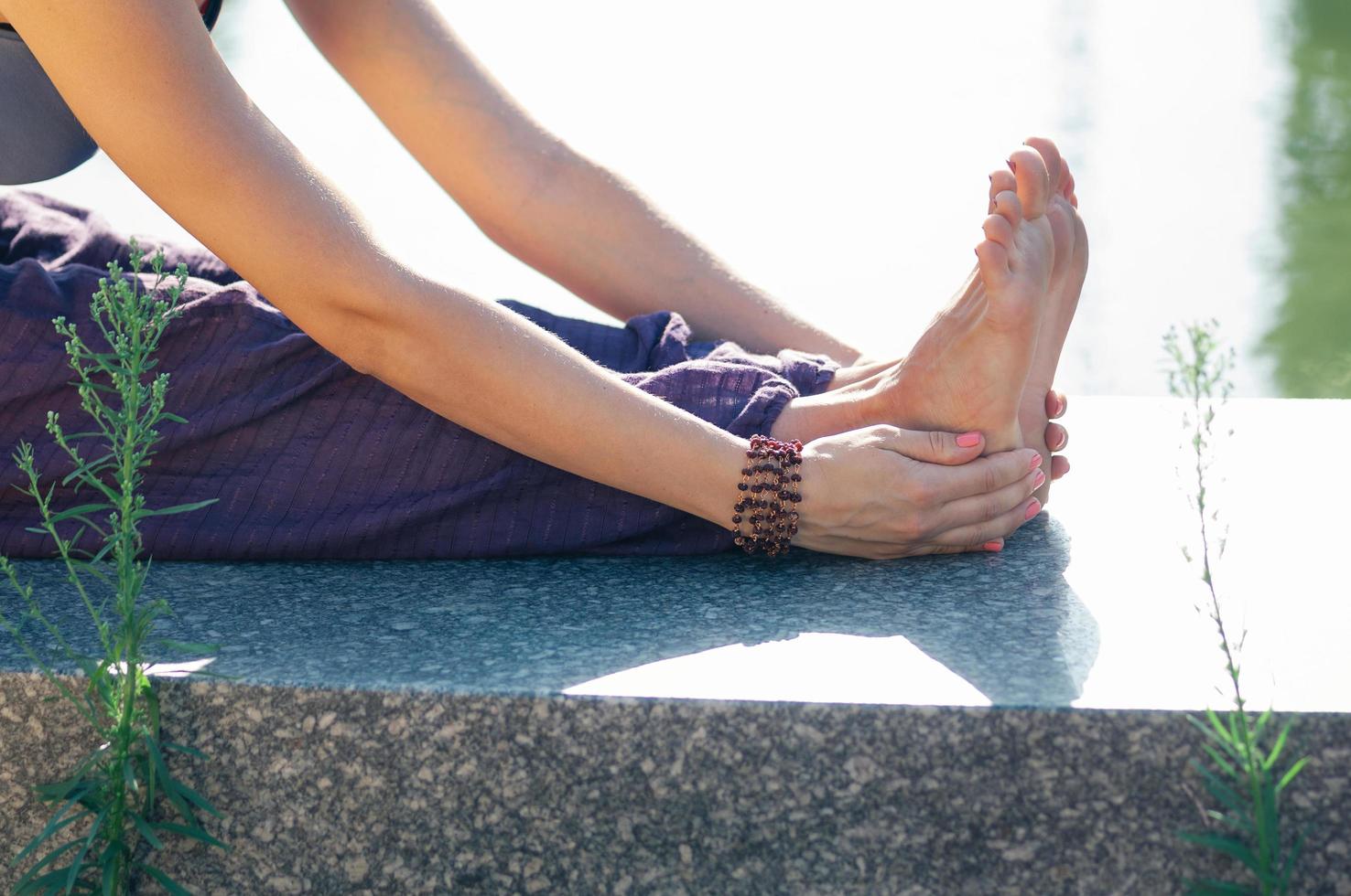 Closeup female hand holding foot stretching pose photo