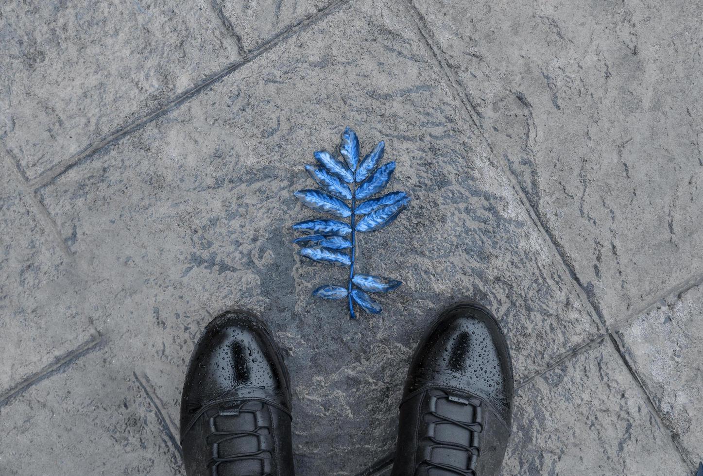 Black leather boots against the wet stone surface photo