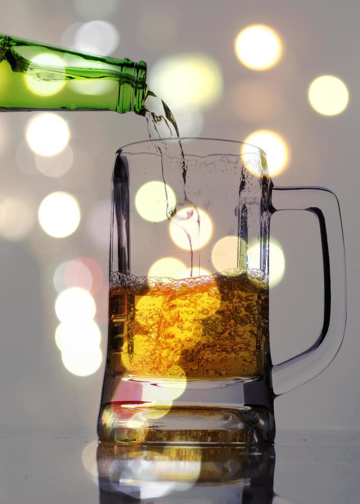 Pouring beer into a glass with spot lighting blur background photo