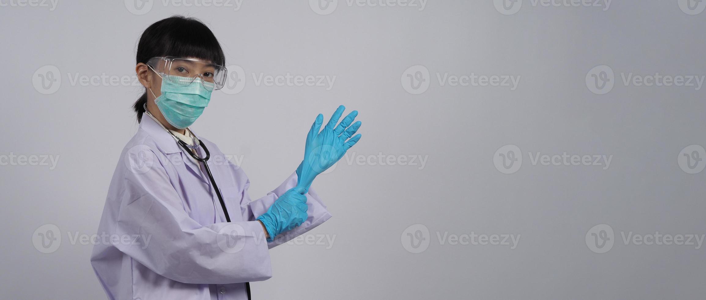 usando guantes. El médico asiático usa guantes de manos de nitrilo de goma azul. foto