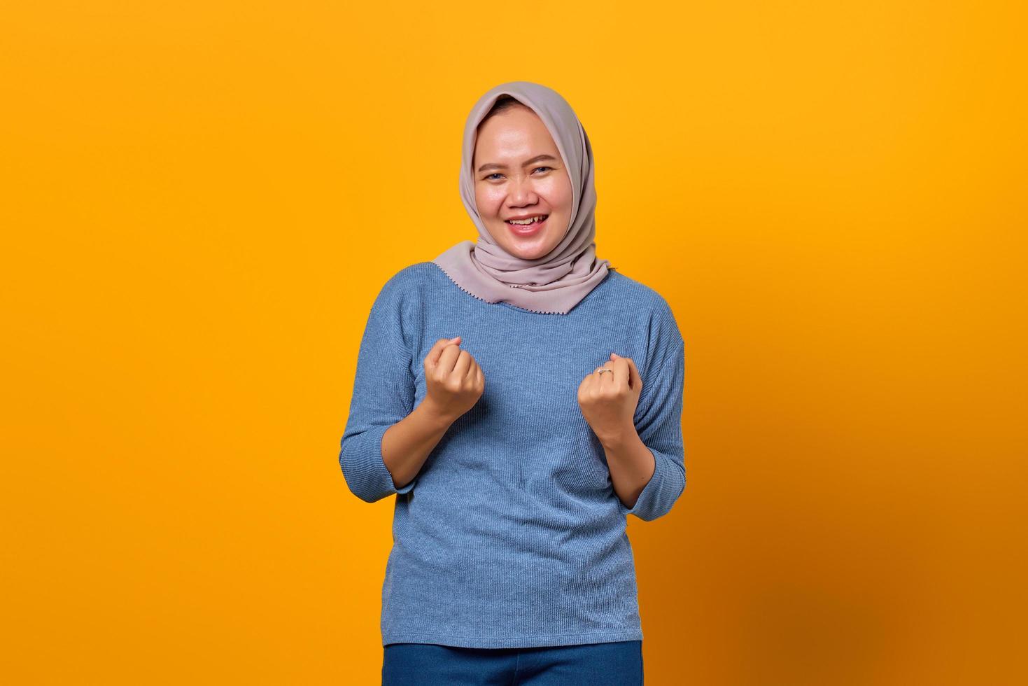 Portrait of cheerful attractive Asian woman celebrating success photo