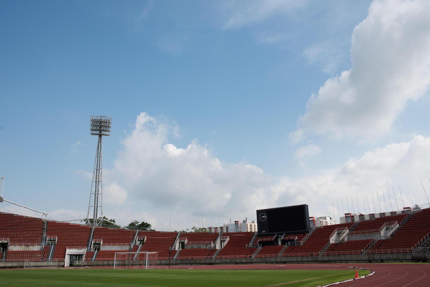 Fondo del estadio con un campo de césped verde durante el día. foto