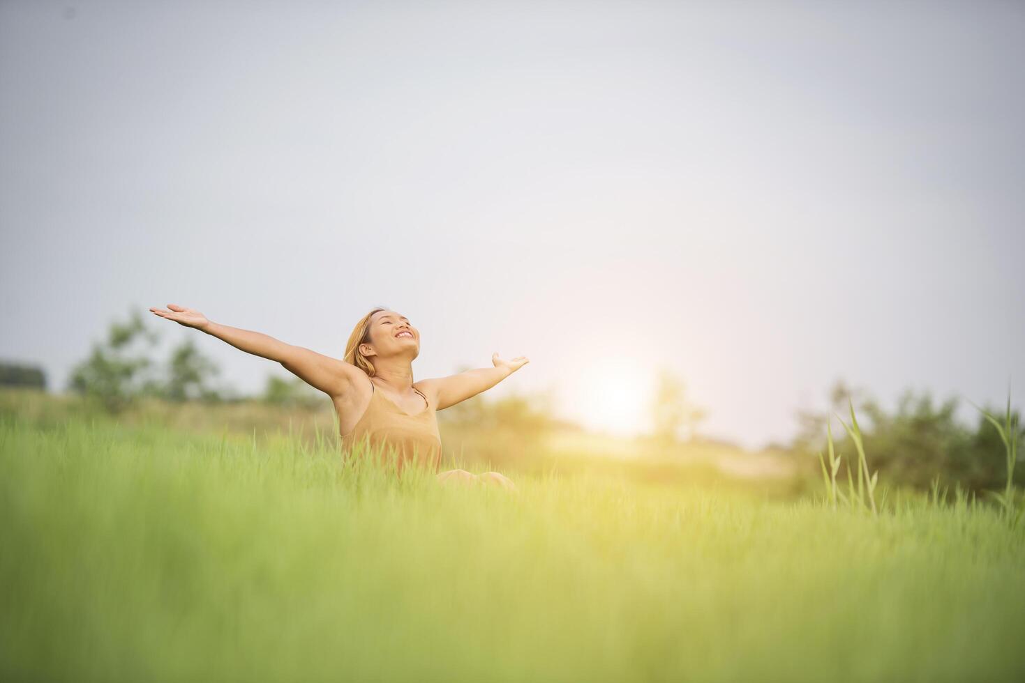 Young woman sitting feel good in grass field. photo