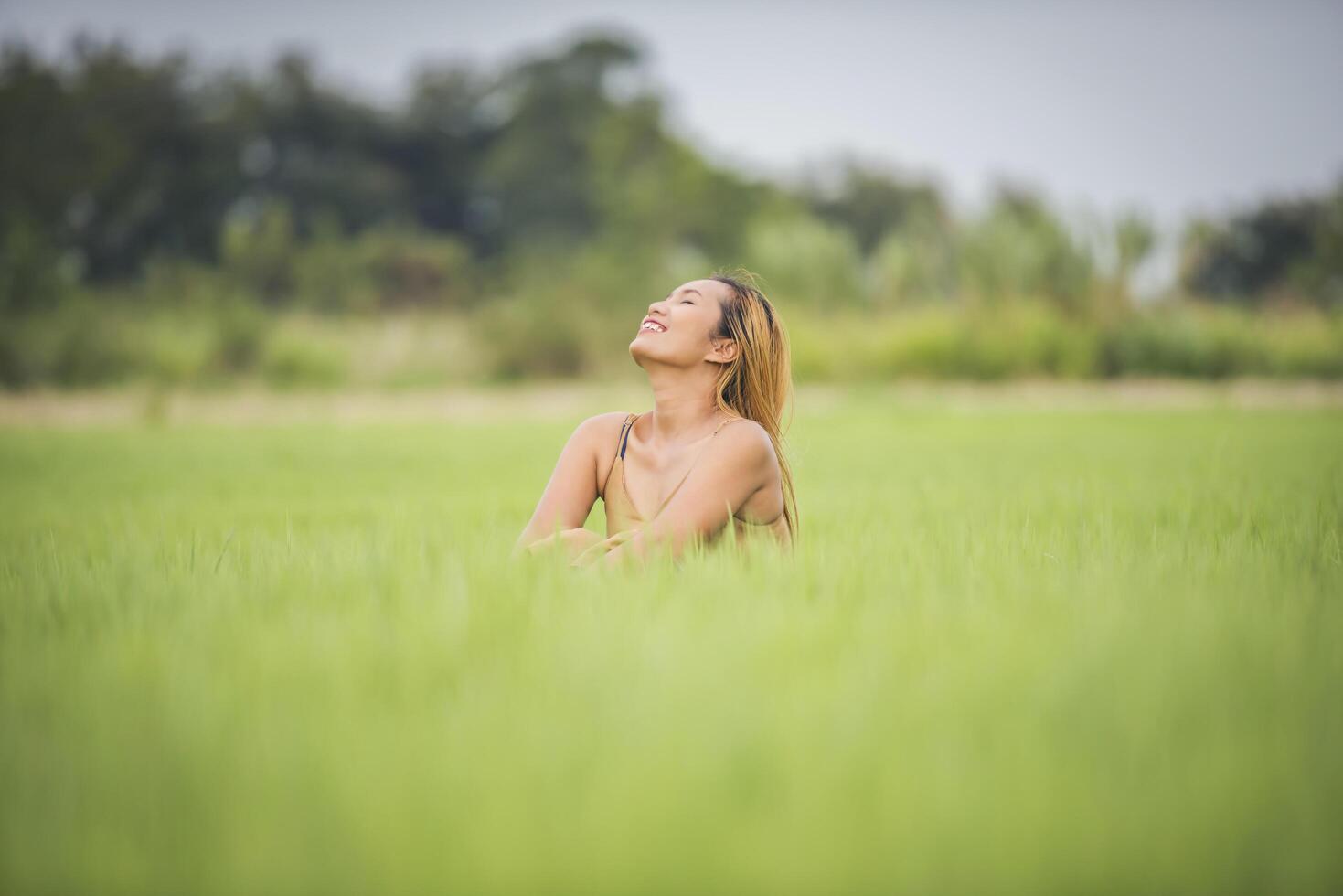 Young woman sitting feel good in grass field. photo