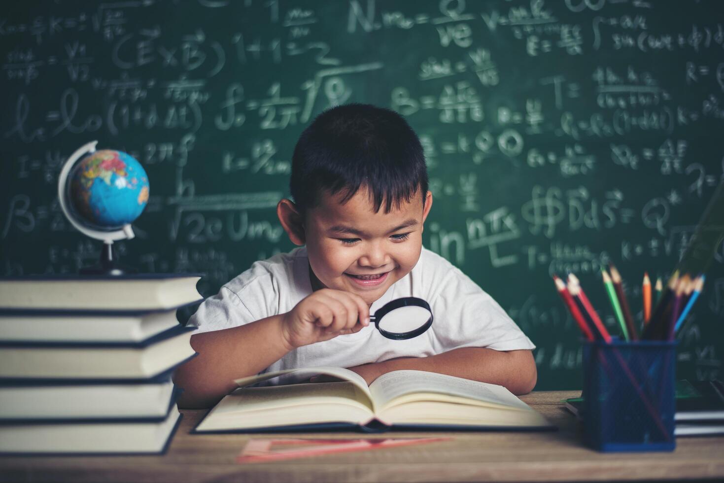 kid observing or studying educational globe model in the classroom. photo