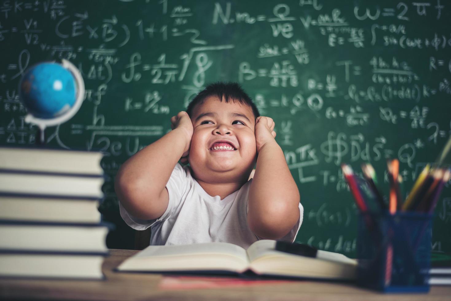 worried boy In classroom with hands on head photo