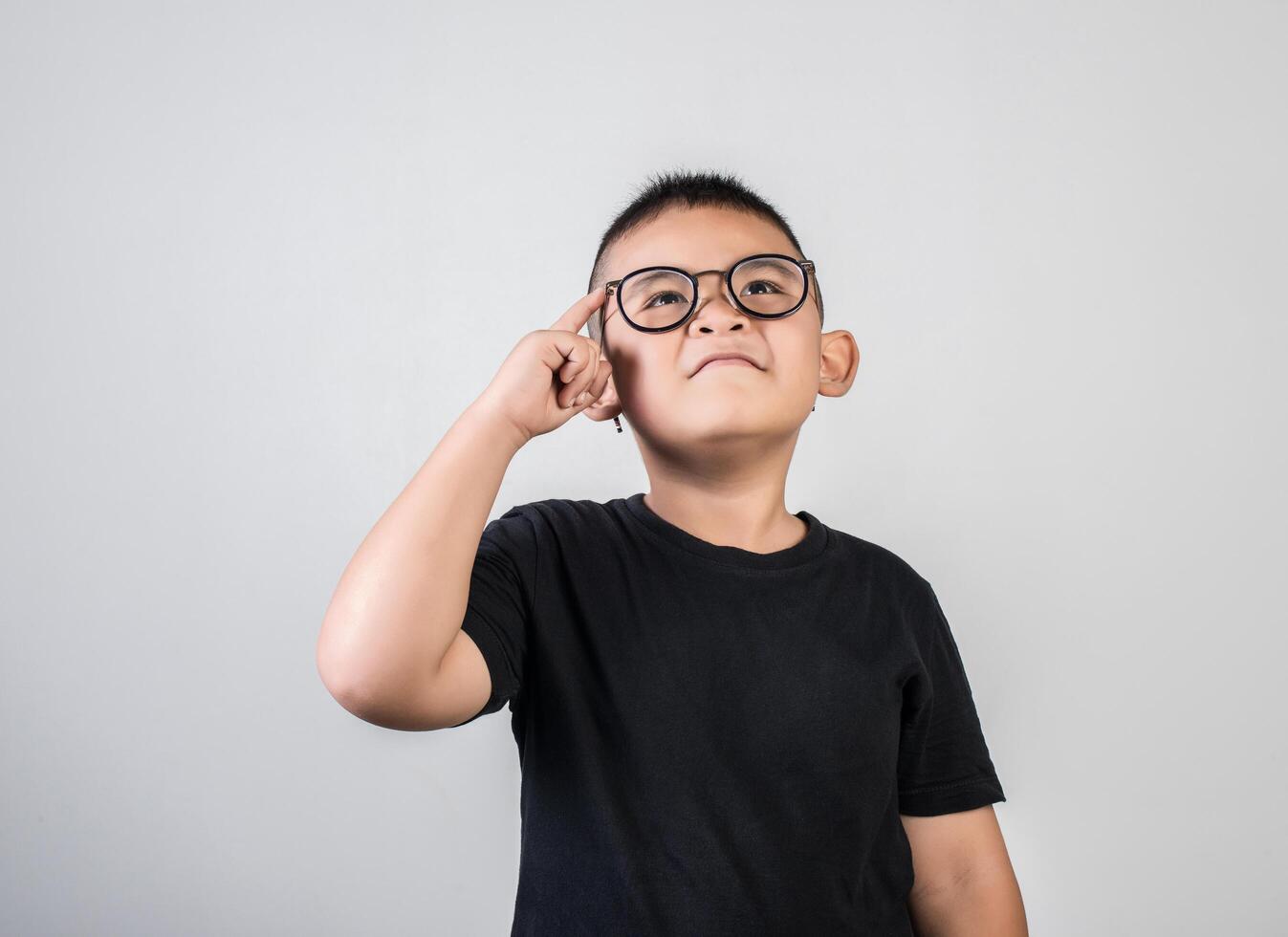 divertido, genio, niño, pensamiento, en, tiro del estudio foto