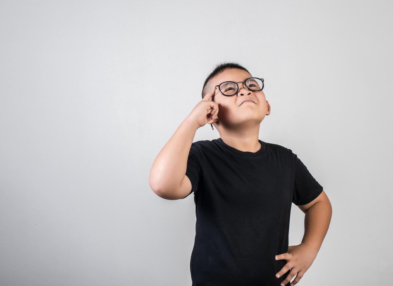 divertido, genio, niño, pensamiento, en, tiro del estudio foto