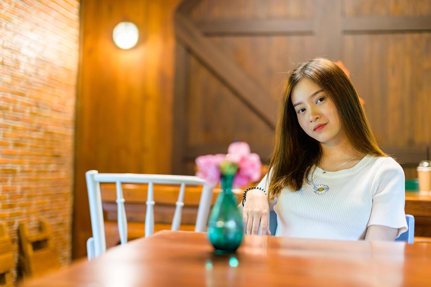 Bella mujer sentada en una silla en un café foto