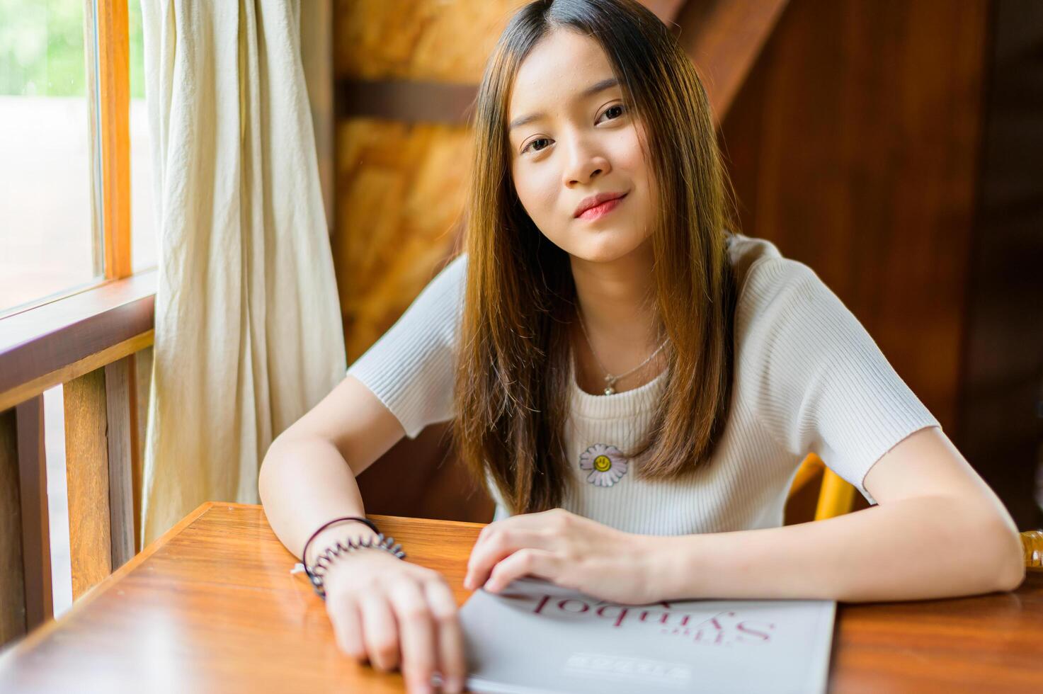 beautiful woman sitting in a cafe reading a book photo