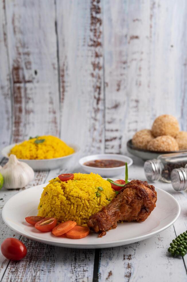 Chicken Biryani in a plate with spices on a white wooden floor photo