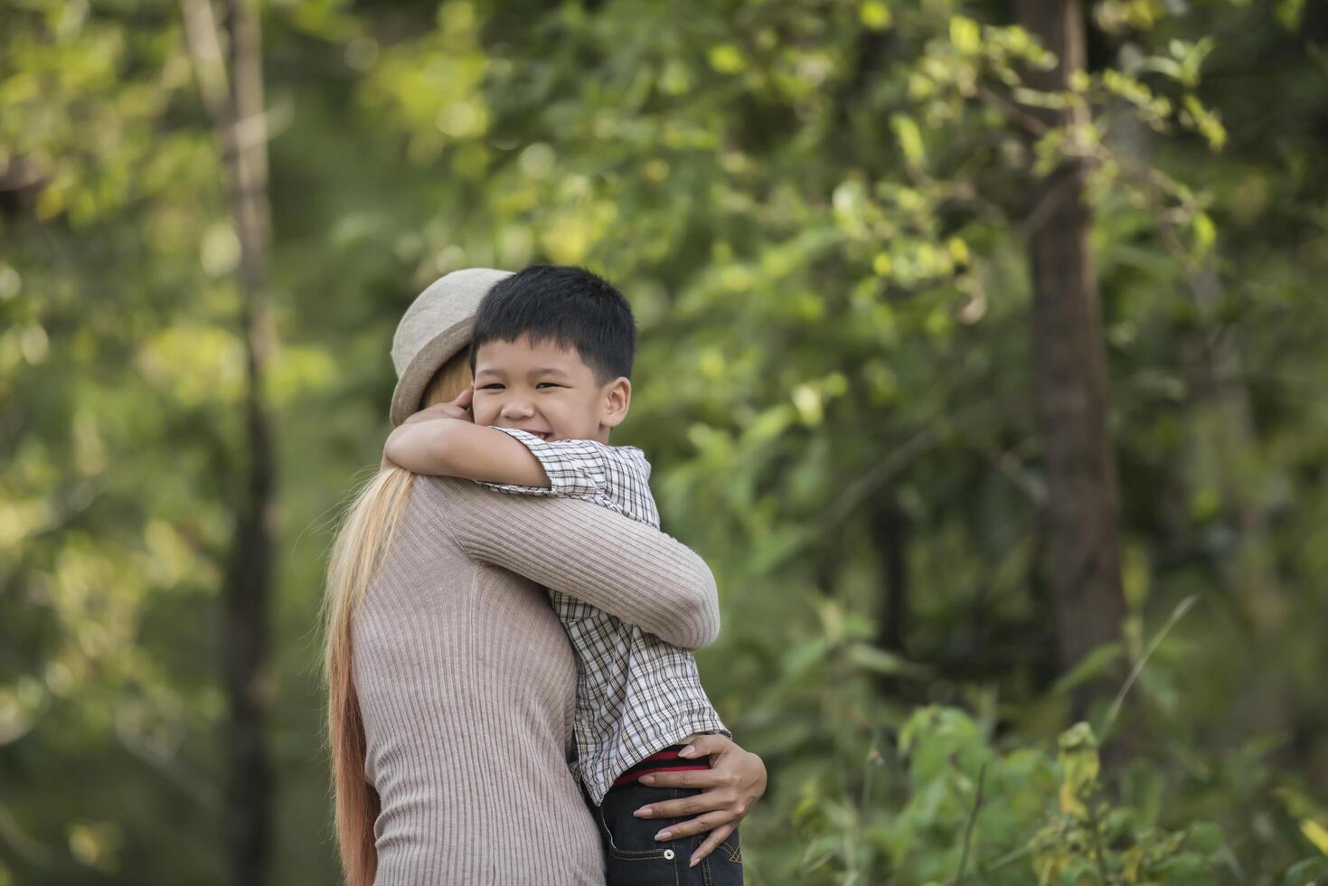 retrato de madre e hijo felices abrazar juntos en el parque. foto