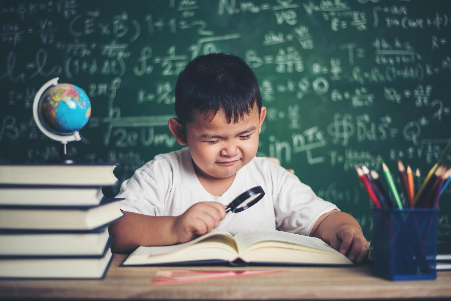 niño observando o estudiando el modelo de globo educativo en el aula. foto