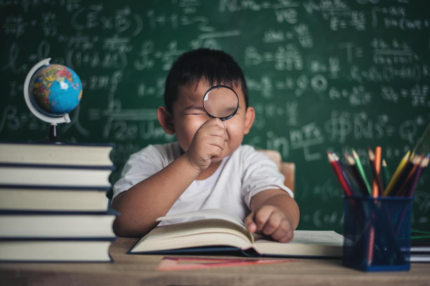 niño observando o estudiando el modelo de globo educativo en el aula. foto