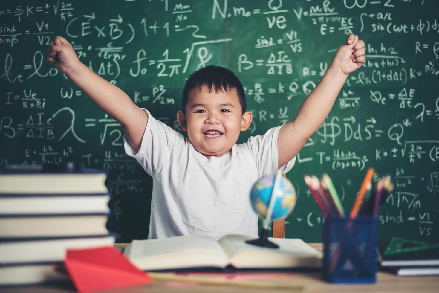 Thoughtful little boy with book in the classroom photo