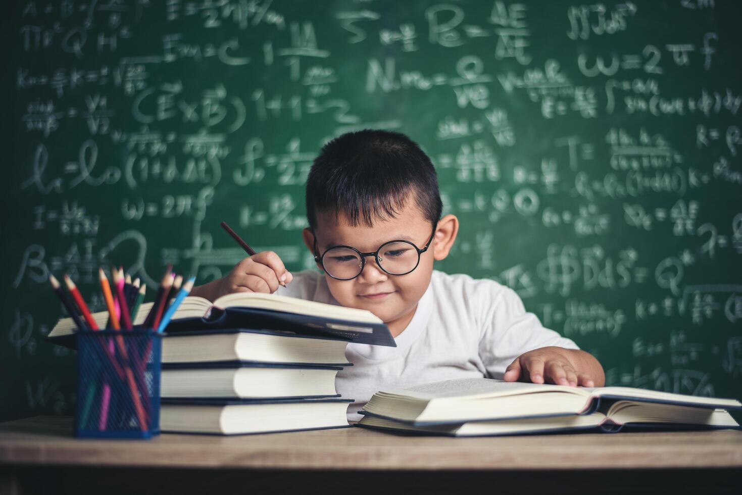 niño escribe un libro en el aula. foto