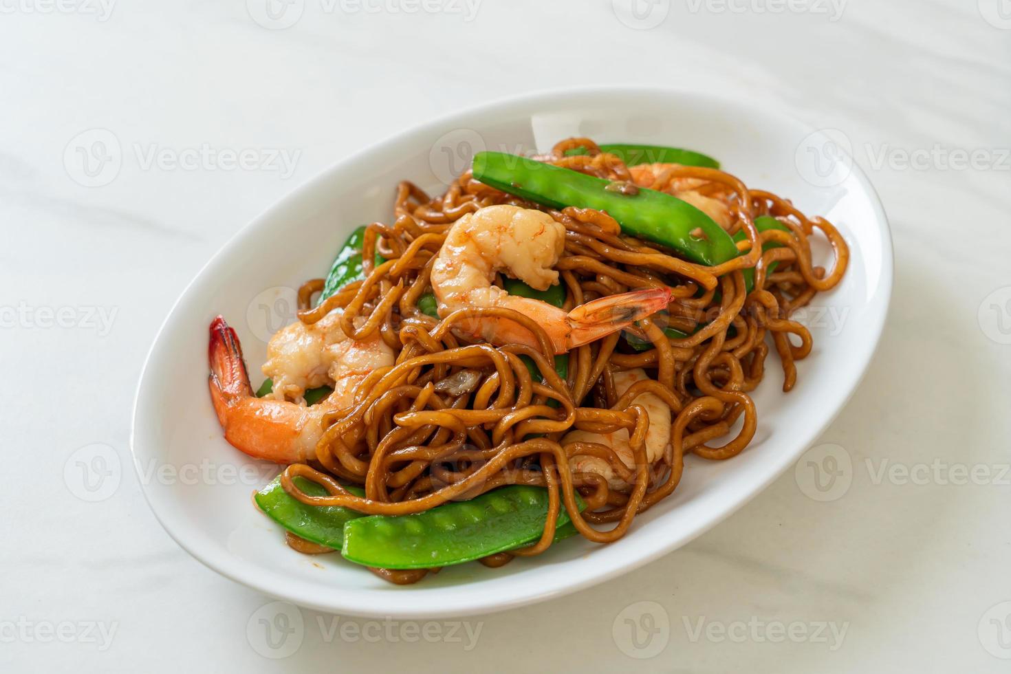 fideos yakisoba salteados con guisantes y gambas foto