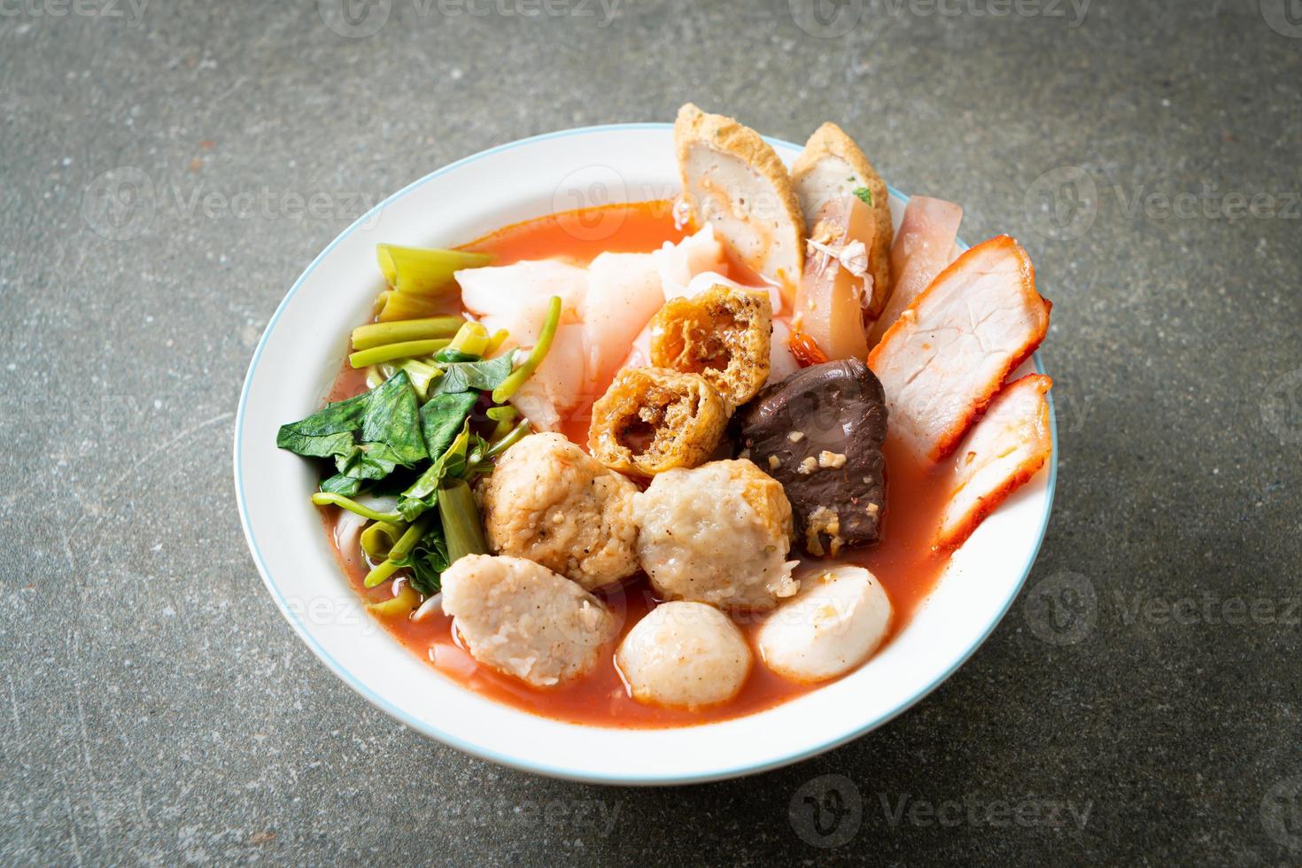 noodles with meatballs in pink soup photo