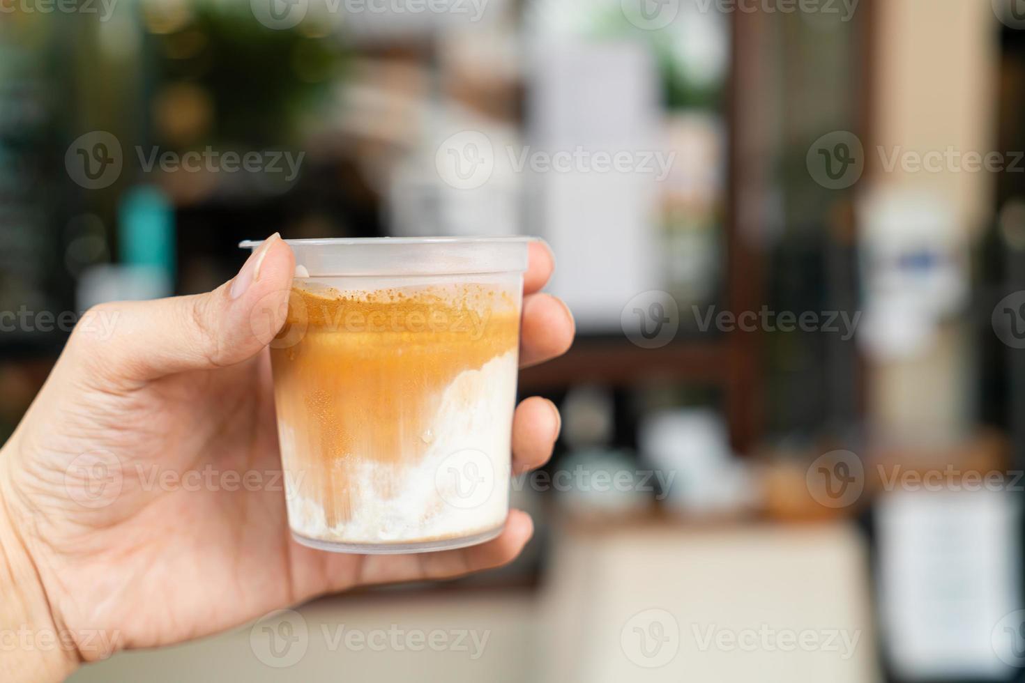 hand holding dirty coffee in glass photo