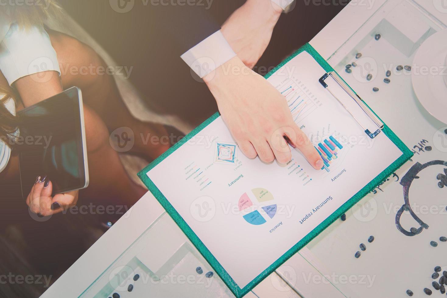 Business manager pointing to summary report photo