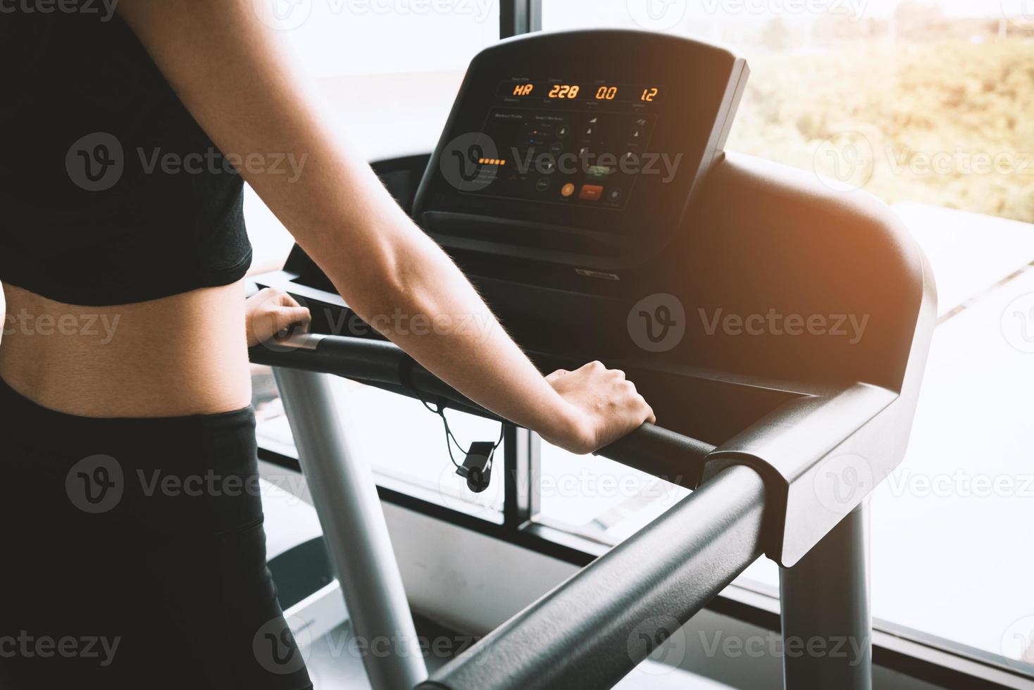 Asian sport woman walking or running on treadmill photo