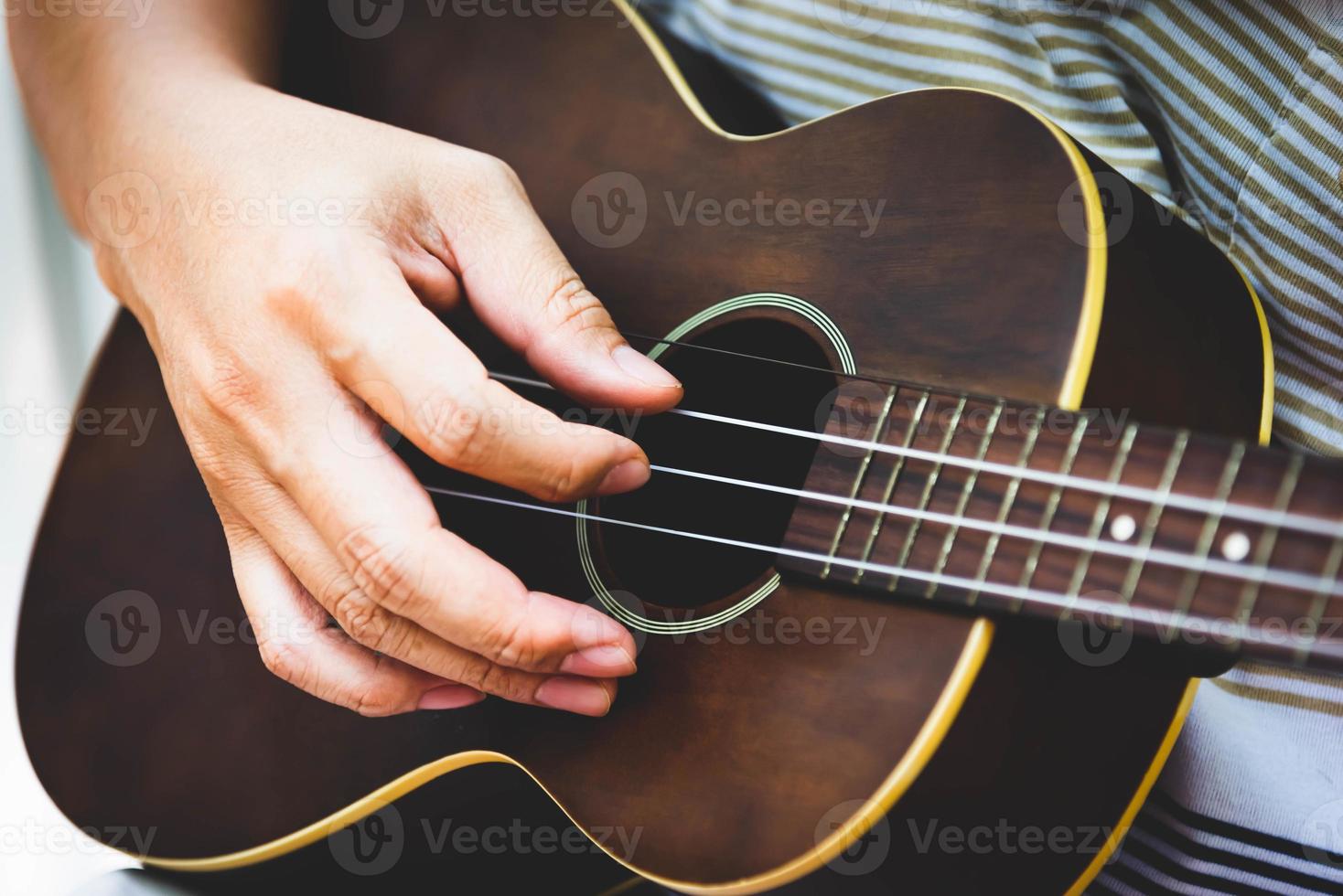 Closeup of guitarist hand playing guitar photo