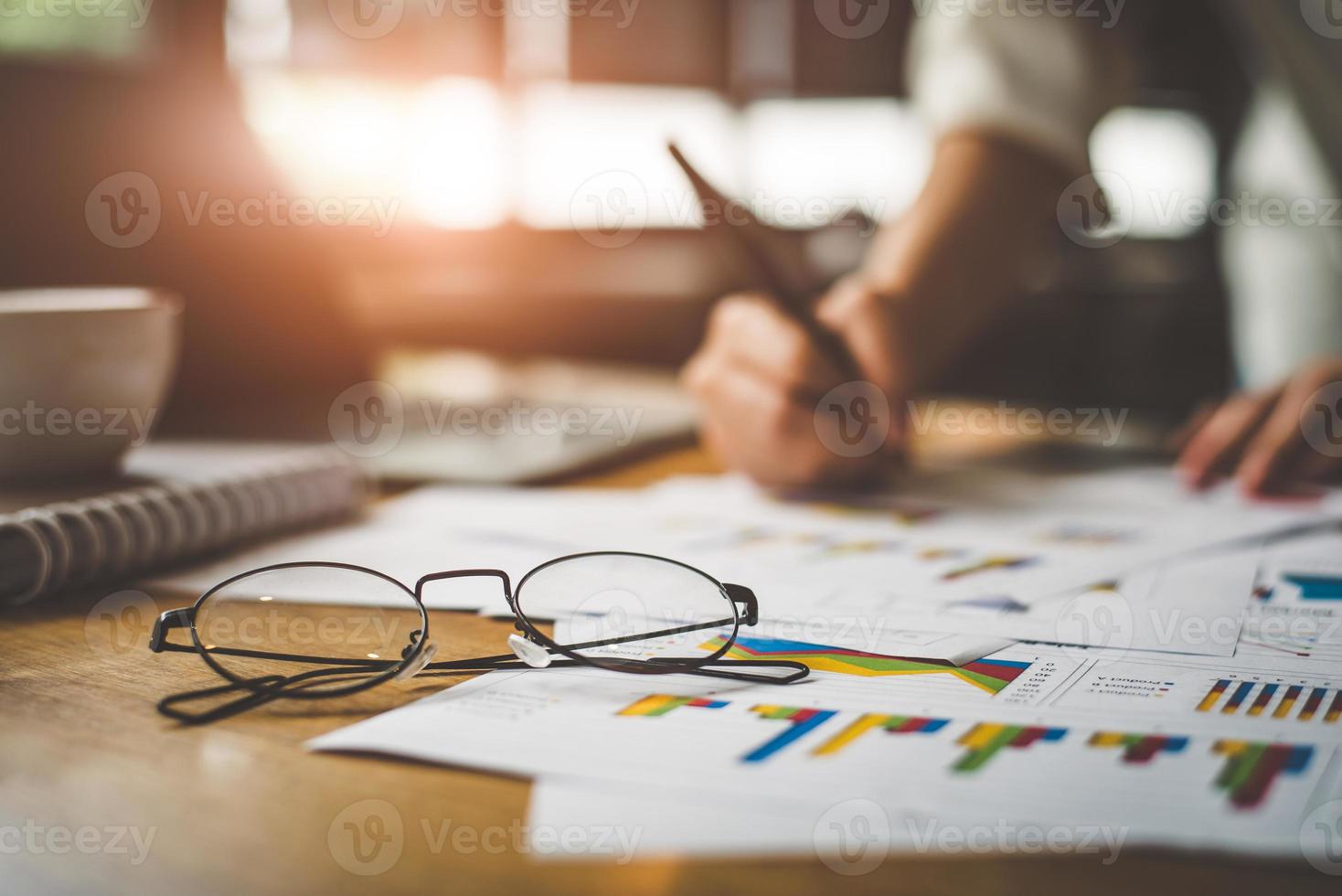 Close up of glasses with businesswoman writing summary photo