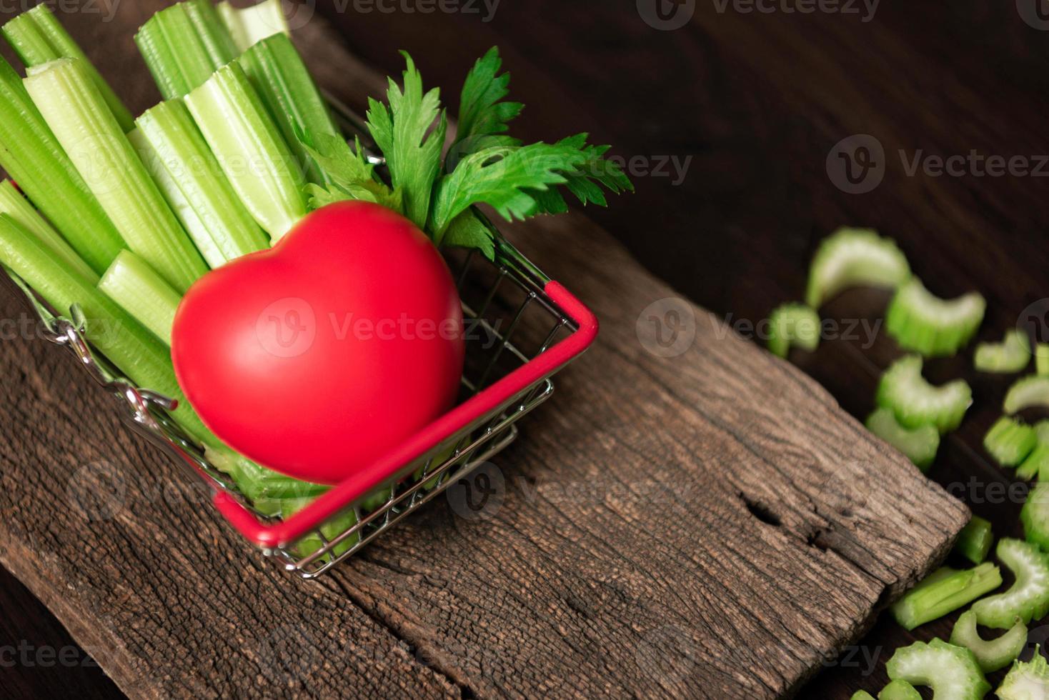 Bunch of fresh celery stalk in shopping basket with leave and heart photo