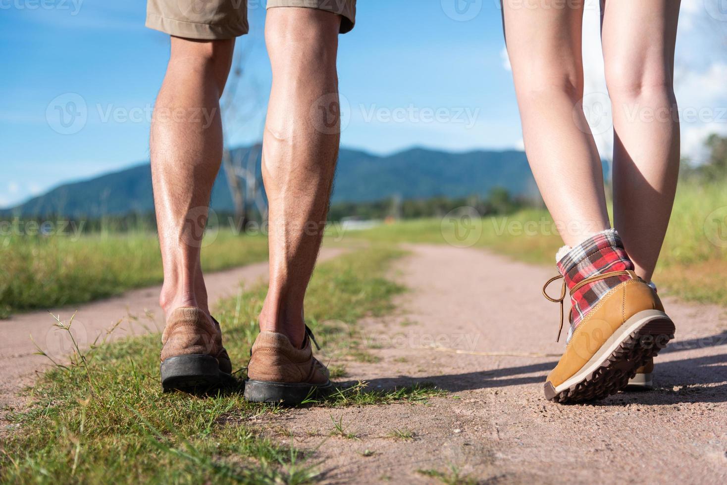 Cerca de la parte inferior de las piernas de dos viajeros caminando por el sendero en la naturaleza foto