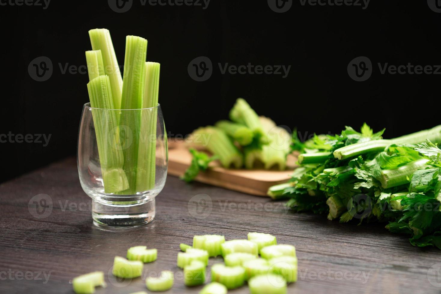 Bunch of fresh celery stalk on wooden table with leaves photo